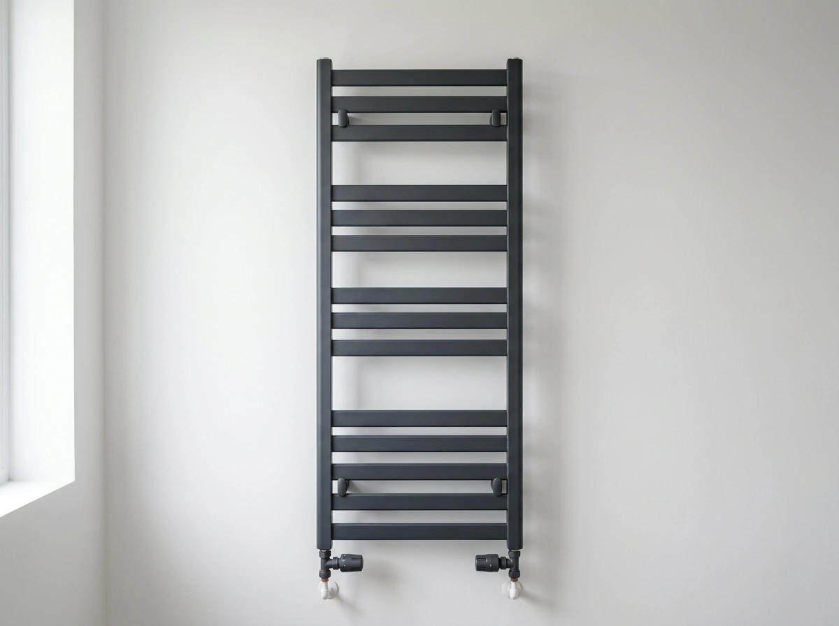 Antraciete handdoekradiator aan een witte wand